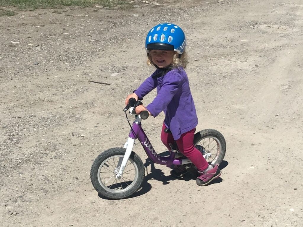girl riding a Woom 1 Balance bike