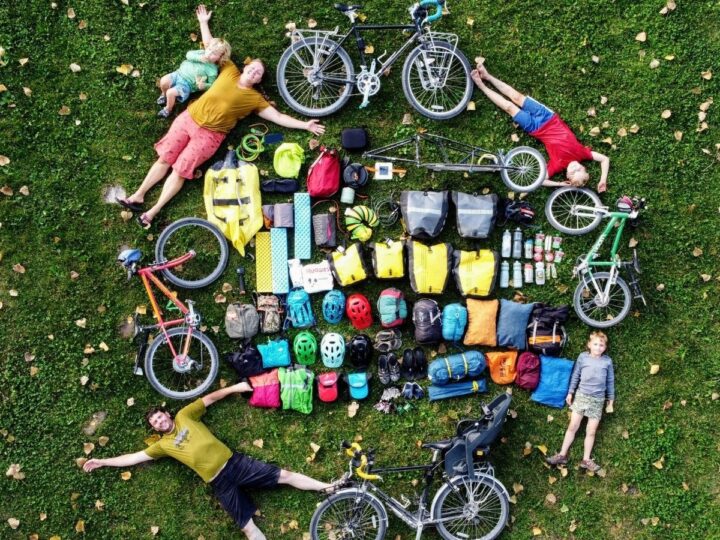 A family is laid out on the ground surrounding all their cycling gear.