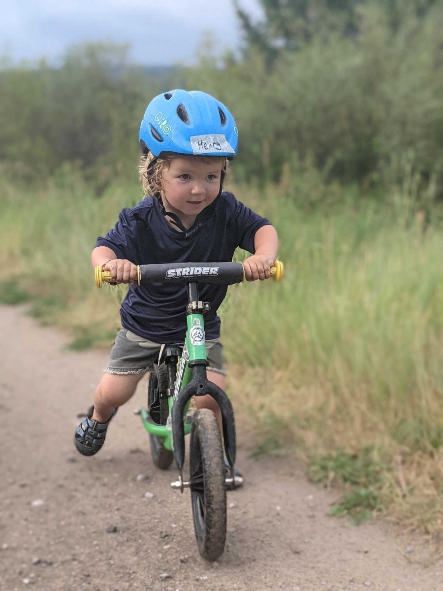 Little boy riding a strider bike with a Giro scamp helmet