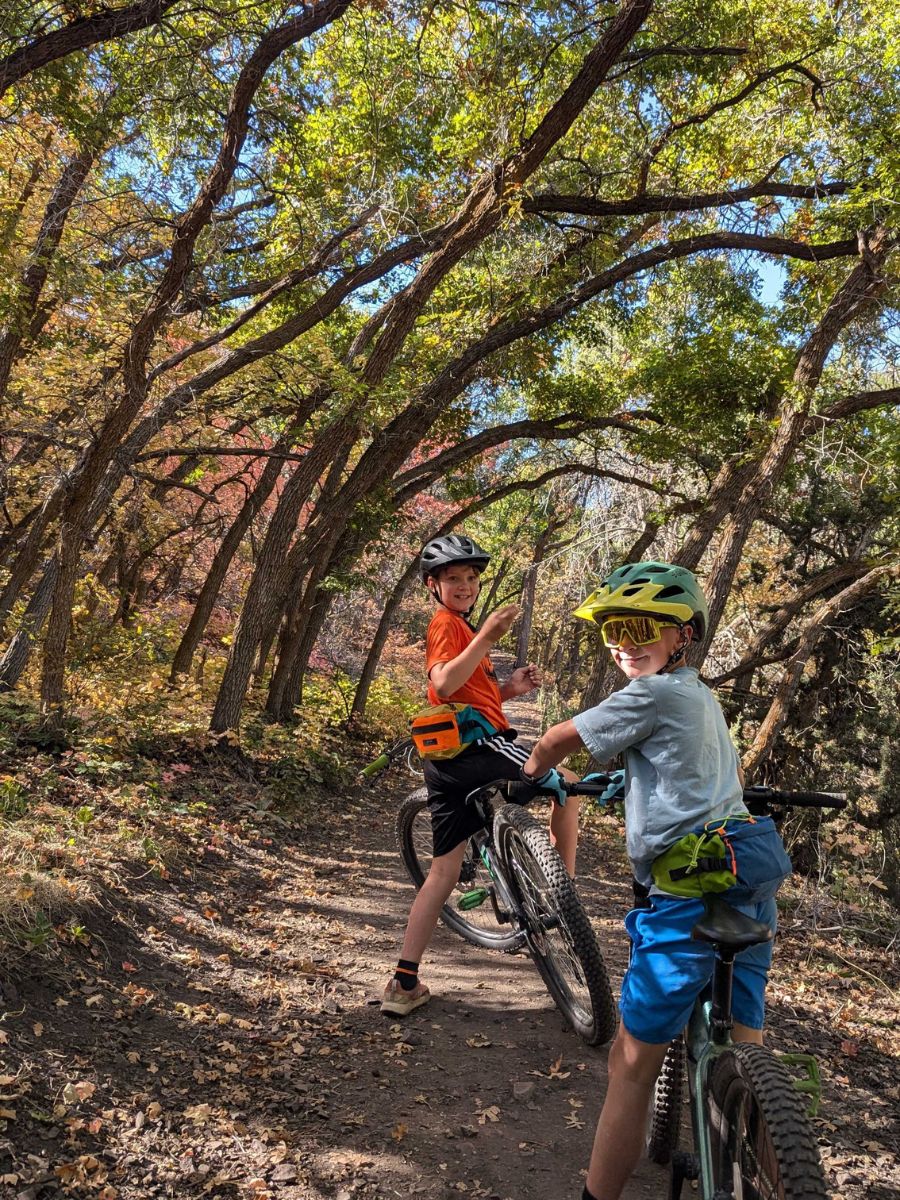 Boys riding bikes on a trail wearing Giro Tremor bike helmets