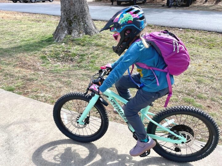 young girl biking with full face helmet