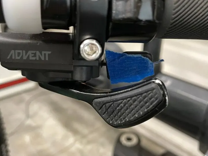 Bike trigger shiffter with a piece of blue tape over the upper.