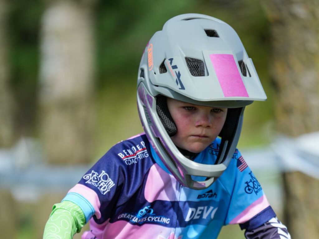 FullFaceAbusnora A young girl rides her bike with a grey Abus YouDrop FF helmet on.