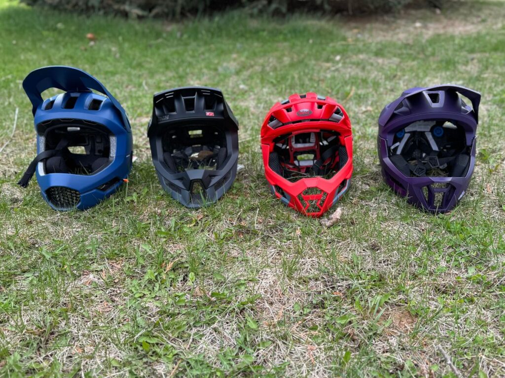 4 full face helmets sit on the grass