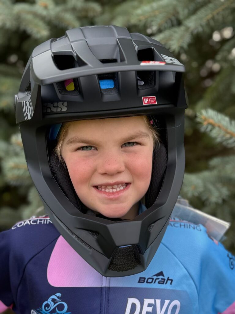 A young girl wears a black IXS Trigger Full Face Helmet