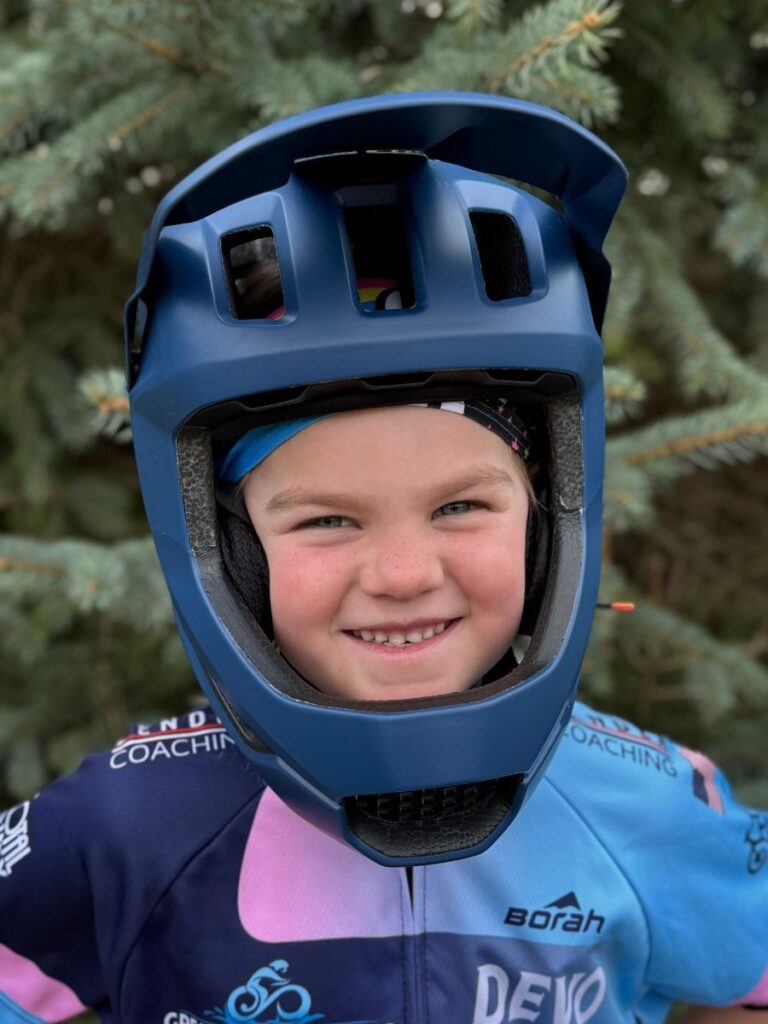 A child smiles with a Poc otocon full face helmet on.