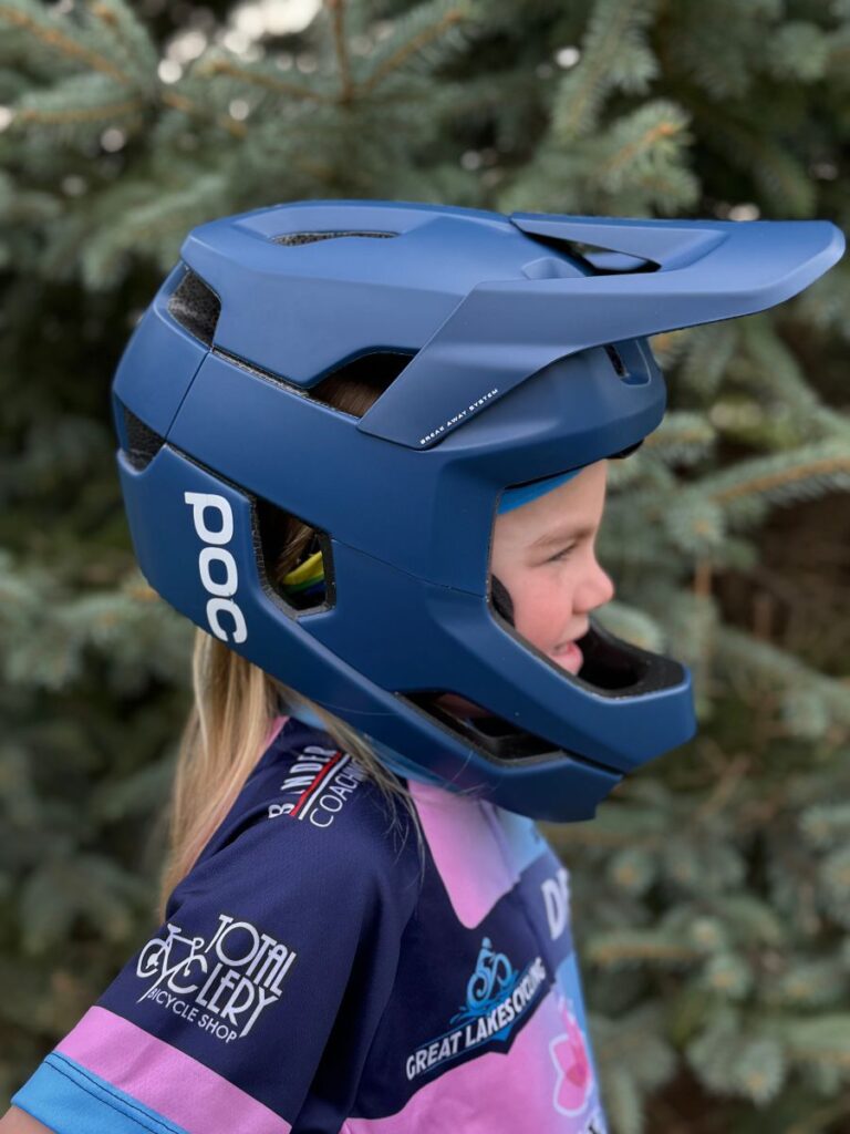 A child poses with a Poc otocon full face helmet