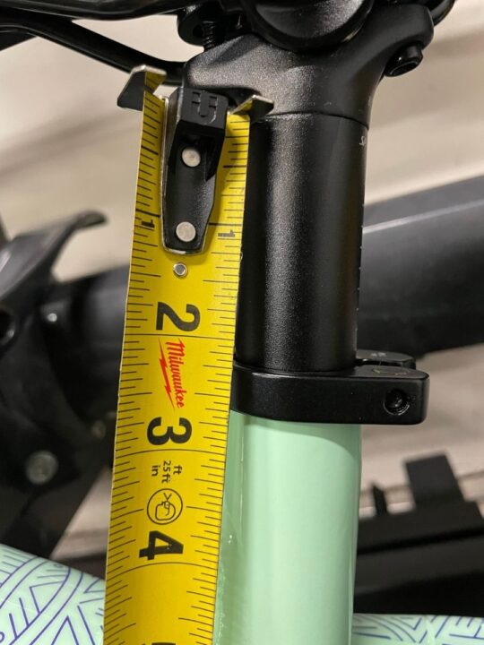 Tape measure next to bike seat showing height of seat.