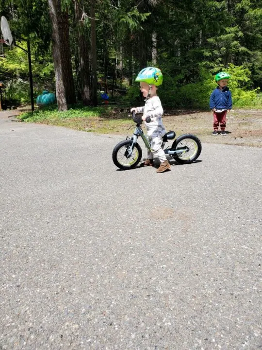 little boy walking his balance bike