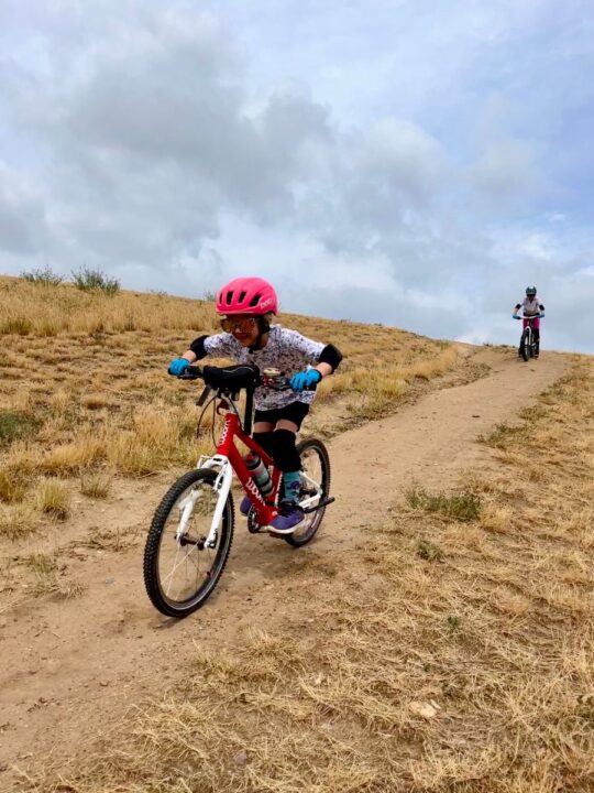 My youngest smoking my eldest on bikes down a hill with pads on. 