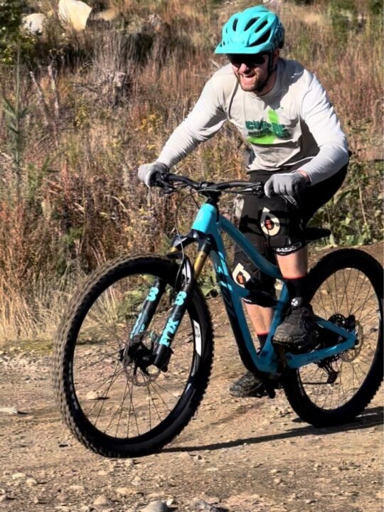 Photo of a man riding a mountain bike and smiling