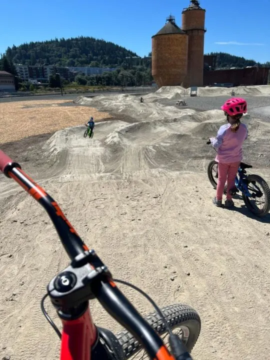 photo of two children riding bikes on the dirt pump track at Waypoint Park