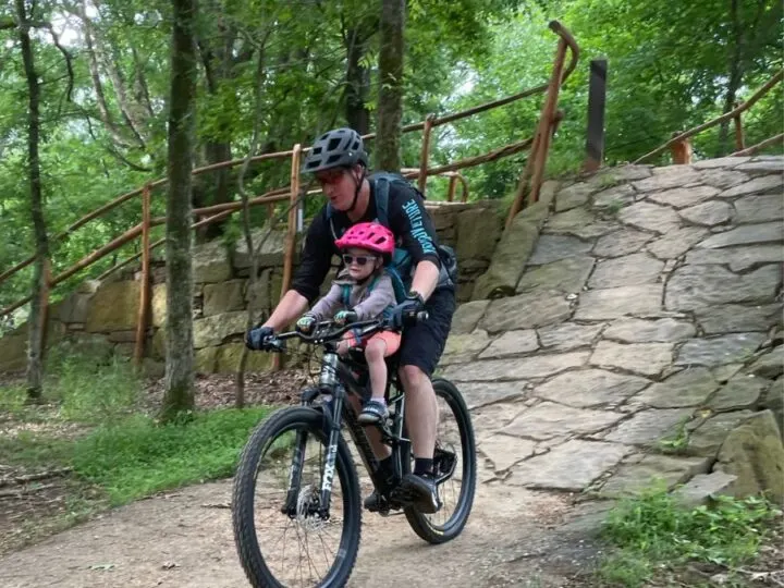 Dad and daughter mountain biking together using the Kids Ride Shotgun Pro seat.