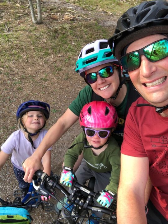 Two adults and two kids mountain biking as a family.