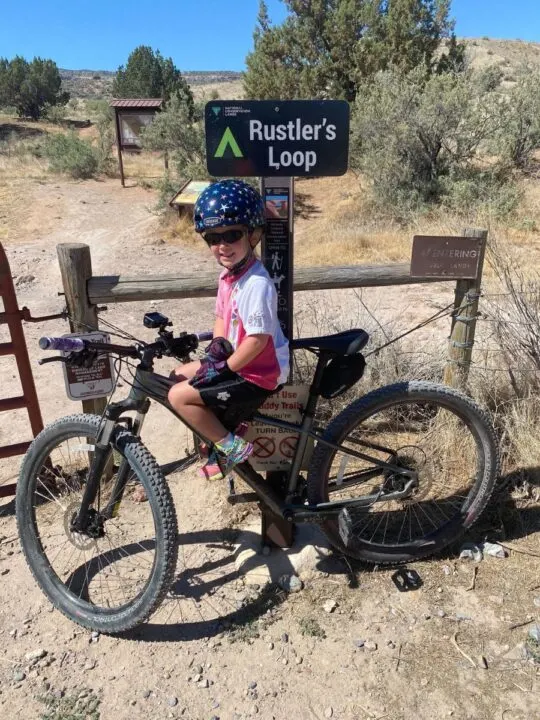 Kid on mom's mountain bike with Little Nutty helmet