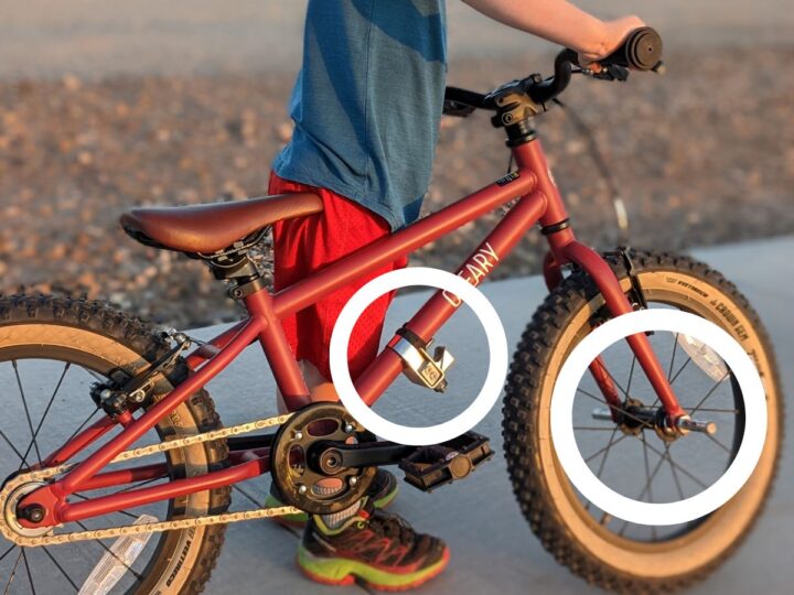 A kids bike with circled parts of hardware.