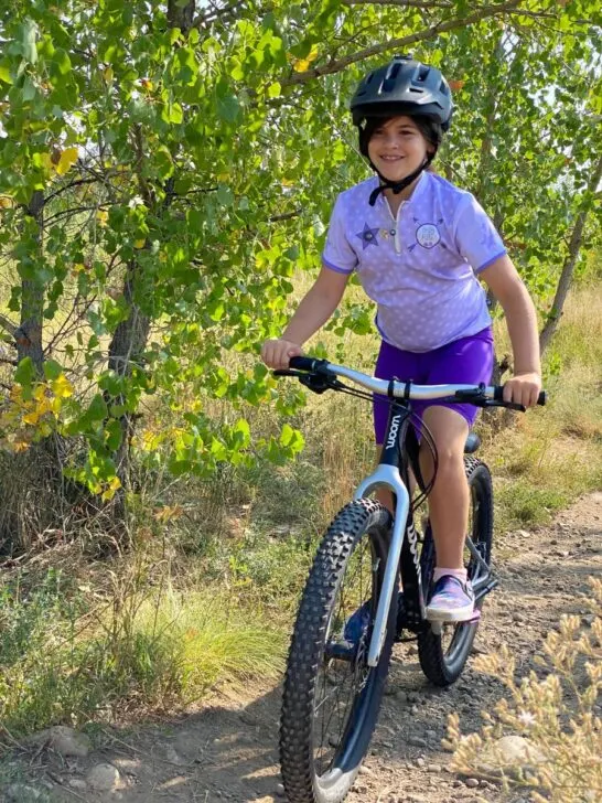 Girl riding bike in Aerotech kit.