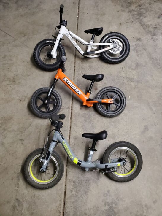 Three balance bikes laid out for comparison all 12 inch wheels.  Dirt hero, stider, and guardian