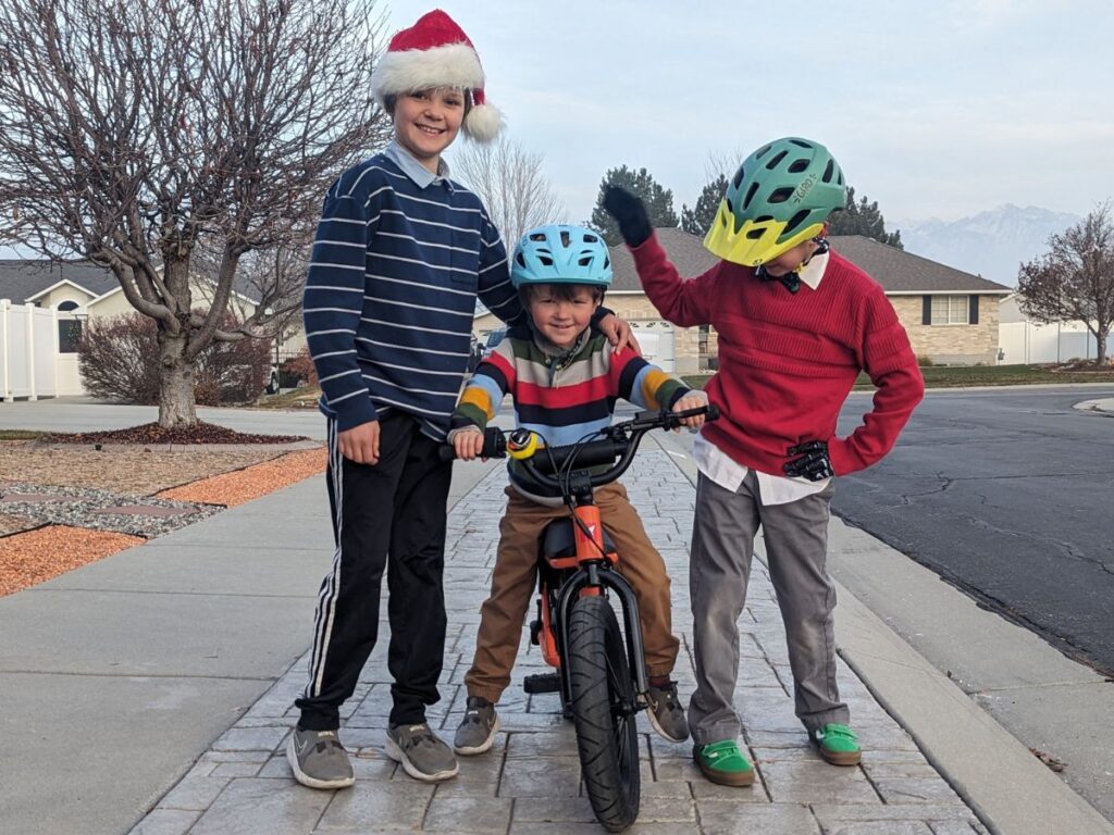 Three boys pose with the Himiway bike.