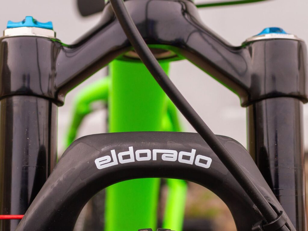 choosingkidsbikefrontfork Front fork of a bike with a green frame.